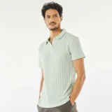 Remera de punto gofrado color celeste con cuello polo y mangas cortas.