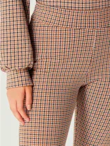 Pantalón legging de tela escocesa en tonos beige, marrón y negro.