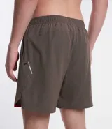 Bermuda deportiva masculina color marrón, con cintura elástica, cordón para ajuste, bolsillos, textura, etiqueta aplicada en la barra y reflectivos laterales.