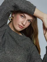 Sweater de lurex color gris con brillo dorado, de cuello redondo y mangas largas.