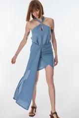 Conjunto de camisa celeste de mangas largas abullonadas y falda turquesa con detalle fruncido y lazo en el lateral.