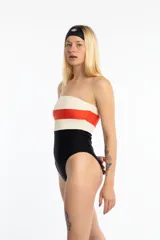 Malla enteriza strapless con diseño tricolor: blanco texturizado en la parte superior, franja naranja en el medio y negro en la parte inferior. Incluye breteles desmontables de lycra.