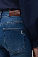 Jean slim de mujer color azul medio, con tiro medio y corte ajustado.