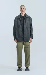 Chaqueta gris de paño con cuello clásico, cierre frontal con botones a presión, bolsillos frontales y corte recto.