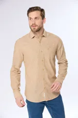 Camisa de lino color beige, de manga larga, con cuello clásico y bolsillo en el pecho.