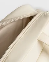 Cartera bowling negra de tela deportiva con manijas superiores y cierre superior. Tiene doble bolsillo frontal con hebilla, bolsillos laterales con broche y charm lateral.