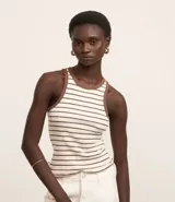 Musculosa blanca con rayas horizontales marrones, cuello redondo y sisas con ribete marrón.