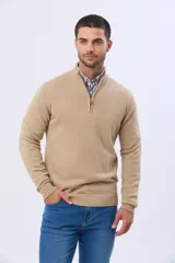 Buzo tejido de algodón color beige, con cuello alto y cierre frontal parcial con detalle de cuero.