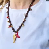 Collar corto hecho en pañuelo marrón con mix de dijes dorados, rojos y blancos.