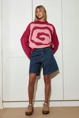 Sweater de punto color rosa con espiral en color fucsia, de cuello redondo y mangas largas.
