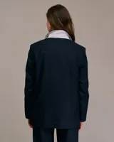 Blazer azul de corte medio largo, con cuello italiano, solapa de muesca, cierre frontal con un botón y bolsillos con solapa.