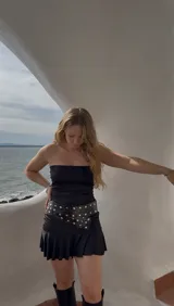 Vestido corto negro sin mangas, confeccionado en jersey de lycra con delantera doble.