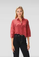 Camisa color ladrillo con bordados florales, de corte holgado, con cuello camisero, mangas 3/4 y cierre frontal con botones.