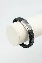 Pulsera de cuero trenzado color negro con cierre metálico plateado.