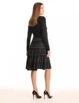 Vestido tejido midi de la marca Julia Jordan, color negro con estampado de líneas verticales blancas. Tiene escote a la base y manga larga.