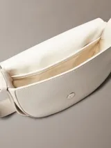 Cartera tipo saddle color blanco, con correa de hombro ajustable y cierre con solapa magnética.