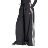 Pantalón Adidas de tela color negro con tres rayas blancas verticales a los costados y logo de la marca en la parte superior.