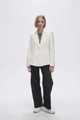 Blazer color crudo de rayon, entallado, con cuello solapa y cierre con un botón.