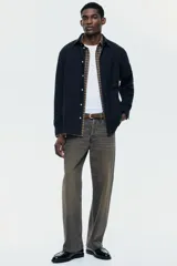 Camisa de manga larga color negro, confeccionada en tejido Oxford, con cuello americano abotonado, bolsillo superior abierto en el pecho y bajo redondeado.