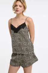 Musculosa con estampado animal print en tonos negro, blanco y verde oliva, con escote en V y detalle de encaje negro en el borde. Tirantes finos ajustables.