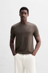 Camiseta slim fit de cuello redondo y manga corta, confeccionada en tejido de algodón con elasticidad.