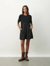 Vestido corto negro con corte evasé, mangas cortas y cuello redondo.