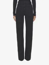 Jean de corte recto y tiro alto, confeccionado en denim rígido de algodón orgánico. Presenta un diseño de cinco bolsillos, cierre frontal con botones y aberturas laterales en los bajos.