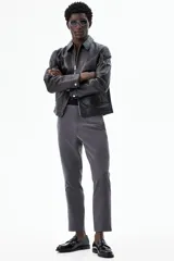 Pantalón de vestir gris oscuro, tobillero, de corte slim fit, con cierre de botón, bolsillos laterales y traseros ribeteados con botón.