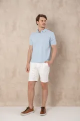 Chomba azul marino de piqué con cuello clásico, tapeta de dos botones y logo de pájaro bordado en color rosa en el pecho.