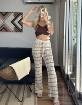 Pantalón de hilo color marrón con rayas horizontales blancas, corte holgado y cintura con cordón ajustable.