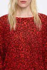 Jersey de lino color rojo con estampado animal print en marrón oscuro, corte recto, escote redondo, manga 3/4 con puño estrecho y sisa cuadrada con fruncido en el hombro.