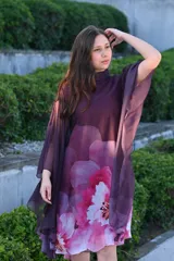Vestido corto con cuello alto y mangas anchas, color morado con estampado floral en tonos rosados y blancos.