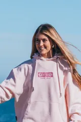 Hoodie rosa con capucha y cordones ajustables. Estampado en la espalda con motivos playeros: sol, olas, conchas y flores de hibisco.