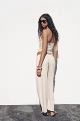 Pantalón ancho color beige, de tiro medio y cintura ajustable con cordones.