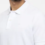 Chomba Arrow de piqué blanca, con cuello polo, manga corta, aberturas laterales y calce regular.