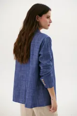 Blazer azul de lino con solapas de muesca, cierre frontal con botón y bolsillos con solapa.