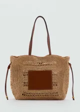 Bolso tipo shopper de fibra natural color beige, con doble asa de mano de cuero marrón y cierre regulable con botón magnético.