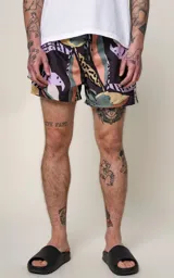 Short de baño de microfibra con estampado tropical de hojas en tonos pastel sobre fondo azul marino. Posee cintura elástica con cordón ajustable negro con inscripción repetida.