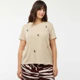 Camiseta color beige de manga corta con cuello redondo y bordados de botas western.