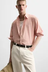 Camisa de manga larga con estampado a cuadros en tonos rosa y blanco.