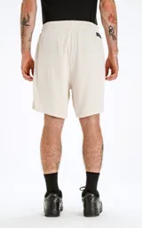 Bermuda color beige de algodón con elástico en la cintura, cordón bordado y bolsillos laterales.