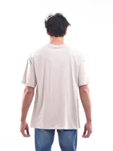 Remera color beige de corte amplio y mangas cortas.