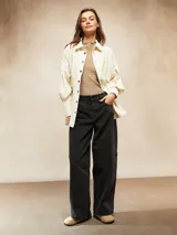 Camisa de pana fina color crudo, con cuello camisero, botones negros y mangas largas abullonadas con puños.