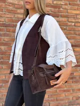 Cartera bandolera de cuero color marrón chocolate, con forro de tela y herrajes dorados. Tiene doble asa de mano y correa larga regulable y desmontable. Incluye bolsillo frontal con cierre y bolsillo interno.