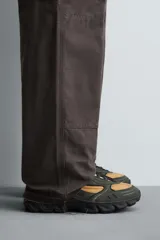 Zapatillas deportivas color crema con cordones, suela gruesa con diseño irregular y detalles en gris.