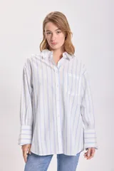 Camisa blanca con rayas verticales celestes, de corte clásico y manga larga.