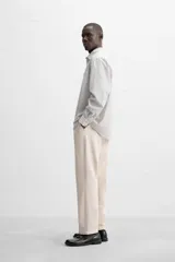 Camisa de hombre relaxed fit confeccionada en tejido de algodón a cuadros. Tiene cuello solapa, manga larga con puños abotonados, bolsillo en el pecho y cierre frontal con botones.