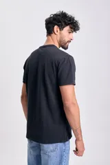 Remera de manga corta en tejido piqué, color negro, con cuello mao y tapeta de botones.