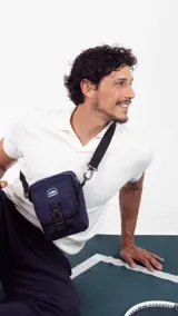Morral bandolera azul marino con bolsillo frontal con hebilla plástica y logo estampado.