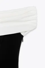 Minivestido negro con escote recto y hombros descubiertos. Presenta una banda superior blanca con frunces.